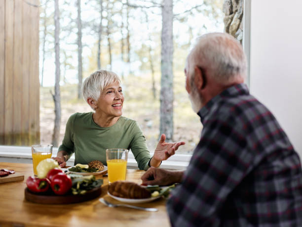 istock Happy mature woman talking to her husband during breakfast at dining table. 1477436414