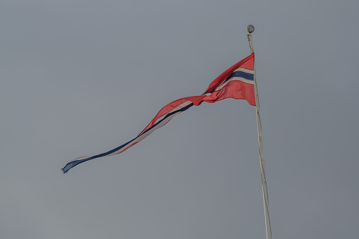 The norwegian flag in the wind against a moody sky background