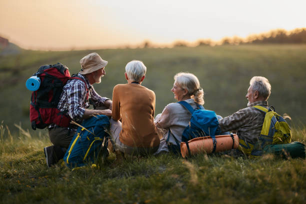 istock Happy mature friends talking on a break from hiking at sunset. 1477436867