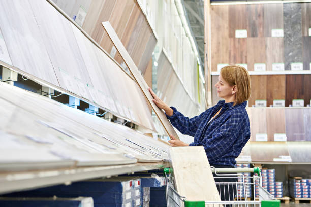 Woman chooses floorboard laminate in store stock photo