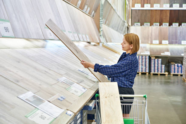 istock Woman chooses floorboard laminate in store 1477437102