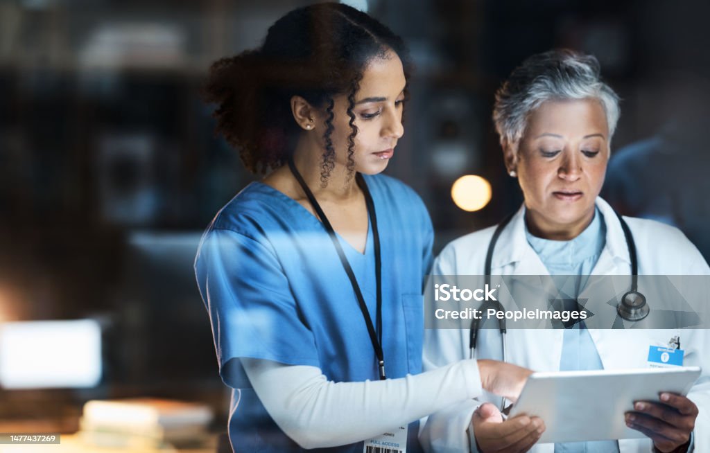Women, doctors and tablet for night medical research, surgery planning and teamwork in hospital. Nurse, healthcare and worker collaboration on technology in late shift for wellness thinking and ideas Doctor Stock Photo