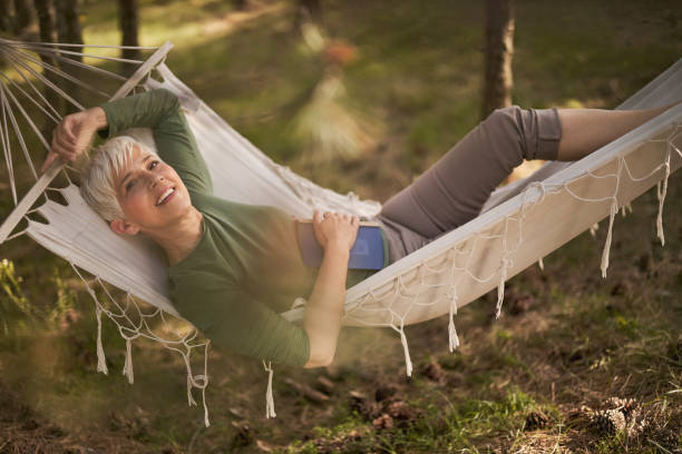 istock Relaxed mature woman enjoying during spring day in hammock. 1477437803