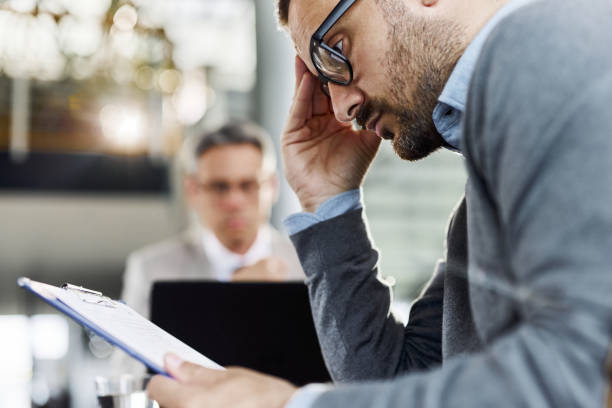 istock Worried man going through contract on a meeting with his agent. 1477437858