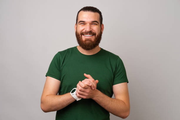 istock Handsome bearded smiling man is holding hands together in front of him. 1477440281
