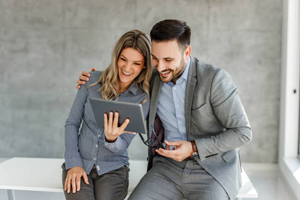 istock Happy business couple reading an e-mail on touchpad in the office. 1477441460