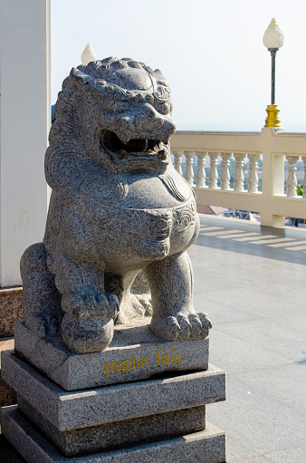 Sculpture of a lion in the oriental style near a Buddhist temple close up