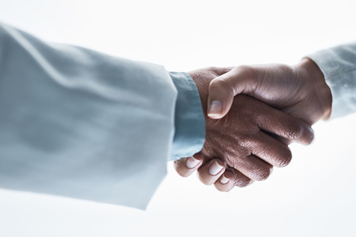 Doctors, women and handshake on isolated white background for healthcare, wellness deal or teamwork collaboration. Zoom, medical and partnership gesture in hospital welcome, people trust or thank you