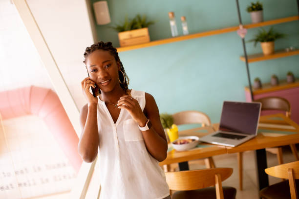 istock Young black woman using mobile phone in the cafe 1477447147