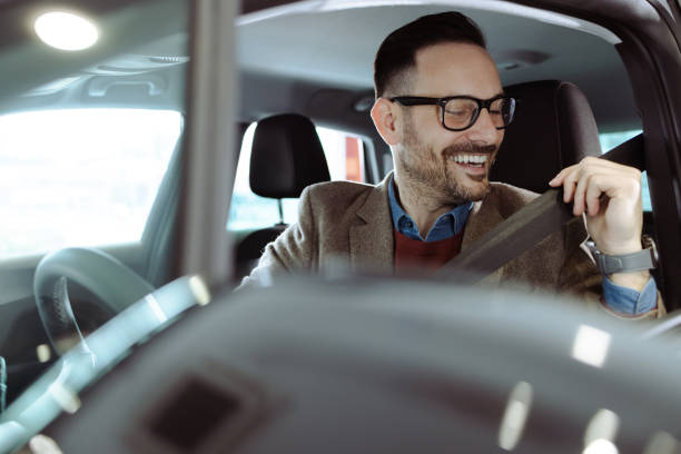 istock Smiling man puts on a seat belt in a car 1477447195