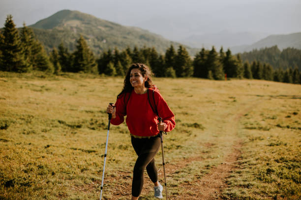istock Young woman walking with backpack over green hills 1477449123