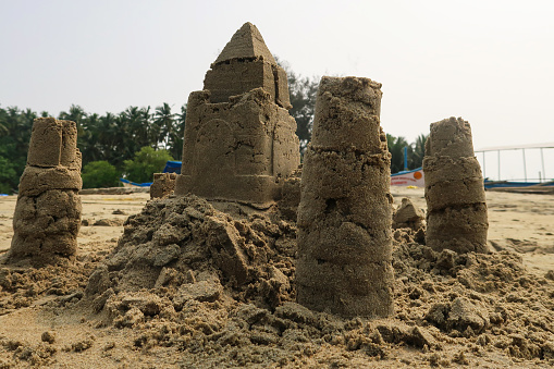 Stock photo showing a complex sandcastle built on the beach in Goa, India. This structure was made with a bucket and spade, with an exterior wall modification to create a fortress style decoration for this sculpture