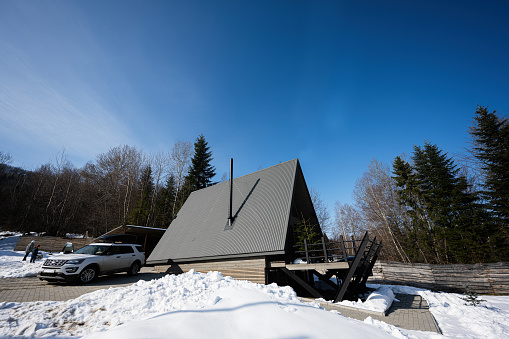 Triangle country tiny cabin house and suv car with roof rack in mountains. Soul weekends.