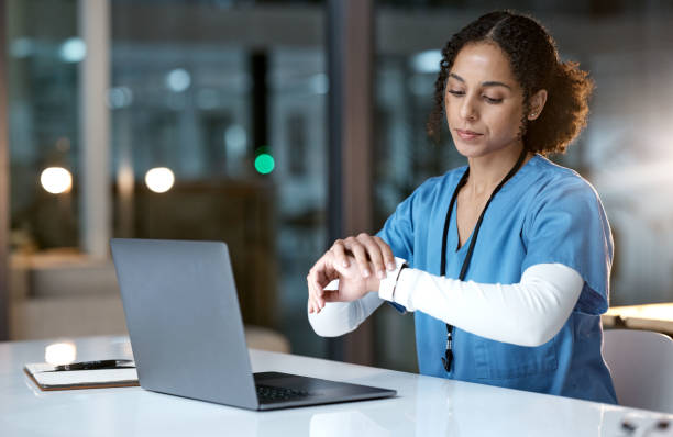 laptop, uhr und nacht mit einer schwarzen krankenschwester, die überstunden macht, um in einem krankenhaus für das gesundheitswesen zu forschen. computer, medizin und zeit mit einer ärztin bei der arbeit spät am abend - überstunde stock-fotos und bilder