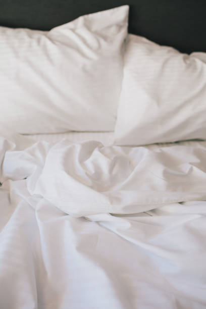 istock Bed and white linens in a hotel room. 1477460377