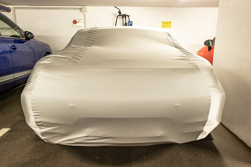 sports car with protective cover in the underground car park