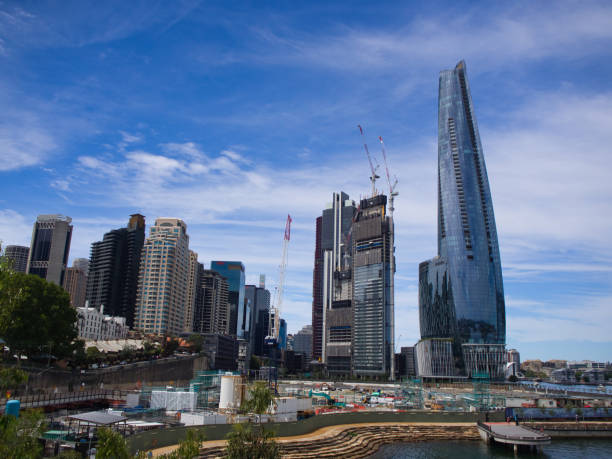 Crown Tower, Barangaroo, Australia - January 08 2022 : Looking Southwards from Barangaroo Reserve with Nawi Cove in front as the Tower reflects the blue sky.