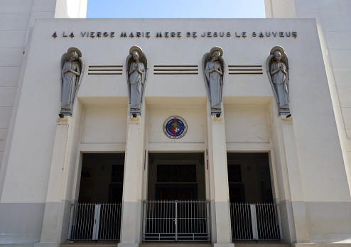 Dakar, Senegal: façade with fulani caryatids of the Cathedral of Our Lady of Victories, also known as Cathedral of African Remembrance, is the largest church in Dakar and the seat of the archdiocese. Monumental building, designed by the architect Charles-Albert Wulffleff. Inscription reads \