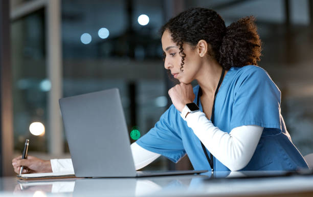 istock Doctor, laptop and writing notes at night thinking about healthcare solution, idea or planning at hospital. Woman medical nurse working late in focus with notebook and computer for research at clinic 1477468725