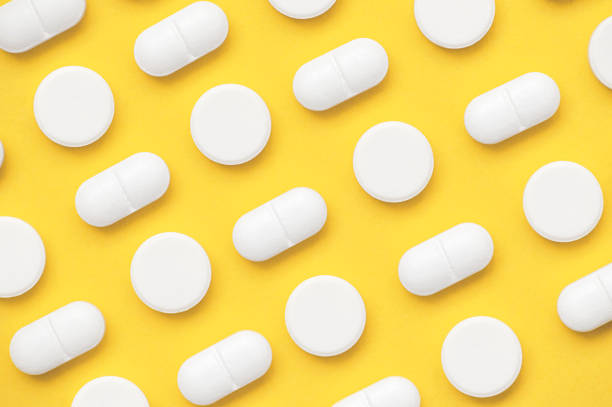 istock A pattern of white pills on a yellow background 1477469138