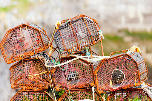 Heap of fishing net baskets and rope on a dock of fishing harbor, Asturias, Spain.