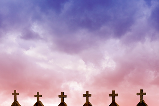 Church cemetery religious crosses in a row in Asturias, Spain. Dramatic dusk sky background.