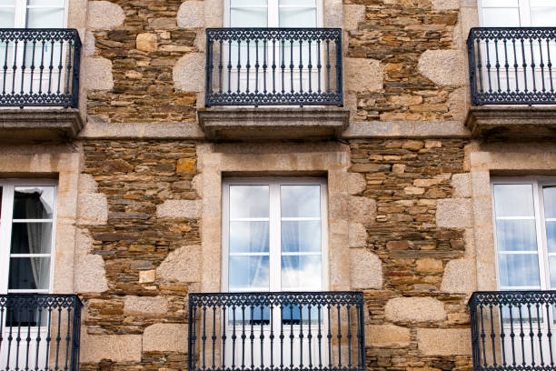 Old building stone wall, cast iron balconies. Mondoñedo village old town, A Mariña, Galicia, Spain.