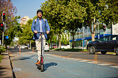 Businessman commuting to work on electric push scooter