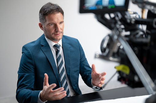 Mature man recording video for blog in studio.