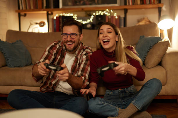 istock Young couple having fun at home playing video games 1477471307