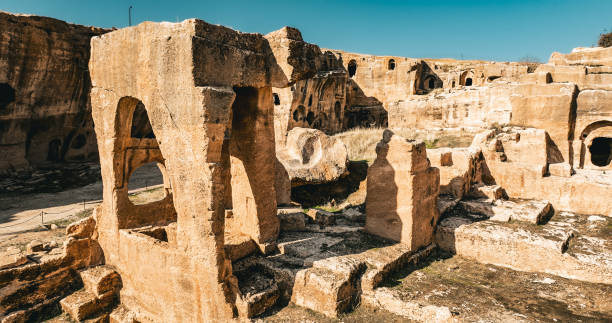 Dara Ancient City is 30 km south east of Mardin, Turkey and was established in the 6th century AD. Historically named Anastasiopolis, this ancient city of Upper Mesopotamia is one of the most famous in the region.
The ancient city of Dara is spread over a large area of 9 km and mostly carved into rocks. Around the city, visitors can see cave houses carved into the rock. Additionally, a church, a palace, a bazaar and related storage facilities, a dungeon, cannon foundry and water aqueduct are still extant. The history of these structures dates as far back as Late Roman-Early Byzantine periods all way to present day Seljuk-Ottoman empires. vista aérea de la antigua ciudad cueva de dara, explore el hito histórico ruinas de mesopotamia de la ciudad antigua de dara en la provincia de mardin, uno de los asentamientos más importantes de mesopotamia, ruinas de la ciudad antigua de dara