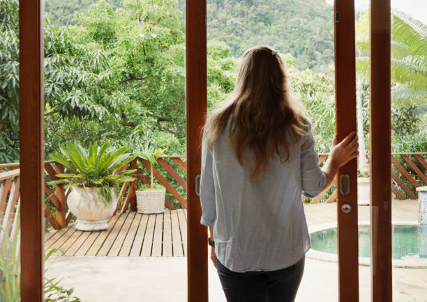 istock Woman looking through her patio doors at the scenic view 1477471679