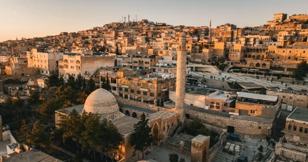 Mardin is a historic city in Southeastern Anatolia, Turkey. The city is known for its fascinating architecture and location: heavily decorated stone buildings cascading down a mountain, watching the vast expanse of the Mesopotamian plains below.
It is known for the Artuqid architecture of its old city, and for its strategic location on a rocky hill near the Tigris River.The old town of the city is under the protection of UNESCO, which forbids new constructions to preserve its façade. vista general de la ciudad de mardin con dron, dron de la ciudad histórica de mardin, paisaje urbano del casco antiguo de mardin, en el medio oriente en mesopotamia, ciudad de mardin, en el medio oriente en mesopotamia, mezquita abdüllatif-latifiye