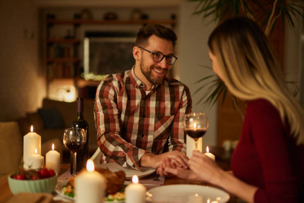 istock Beautiful couple having romantic dinner with candles and red wine at home 1477472913