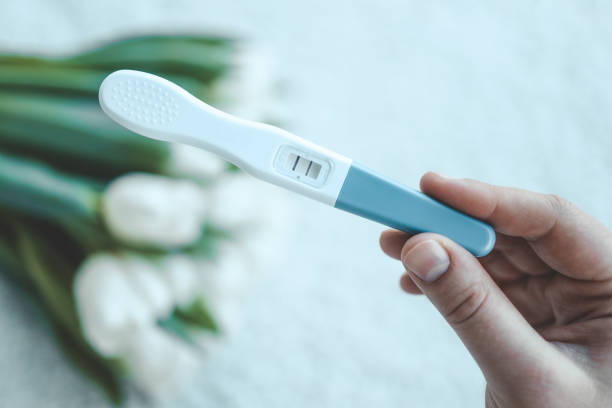 istock Positive pregnancy test on white flowers background 1477473840