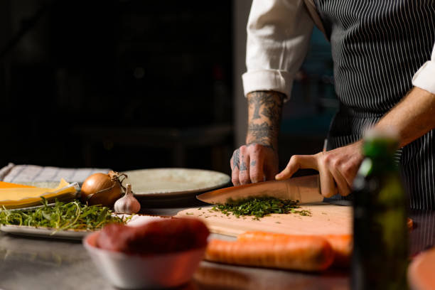 istock Close up of a chef cutting parsley while making a meal in the kitchen. 1477474622