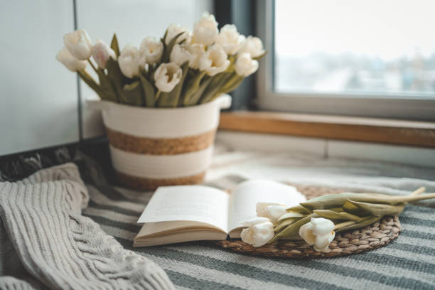 istock Open book, candle and basket with tulips, spring cozy composition in home interior 1477474636