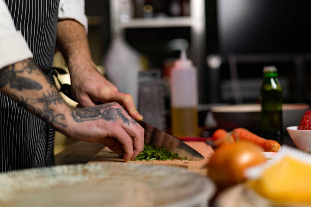 istock Close up of unrecognizable professional chef cutting parsley in the kitchen. 1477474779