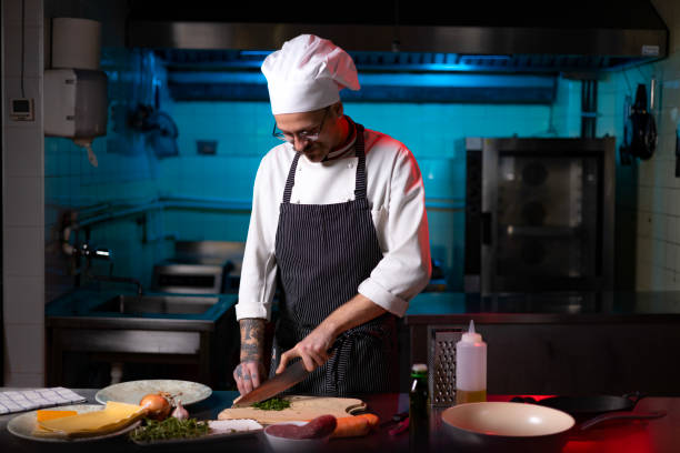 istock Young chef preparing parsley for a meal in the kitchen. 1477474828
