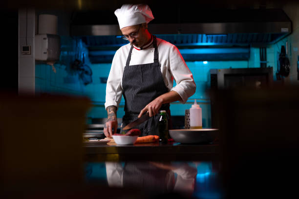 istock Male chef cutting vegetables for a meal in the kitchen. 1477475601