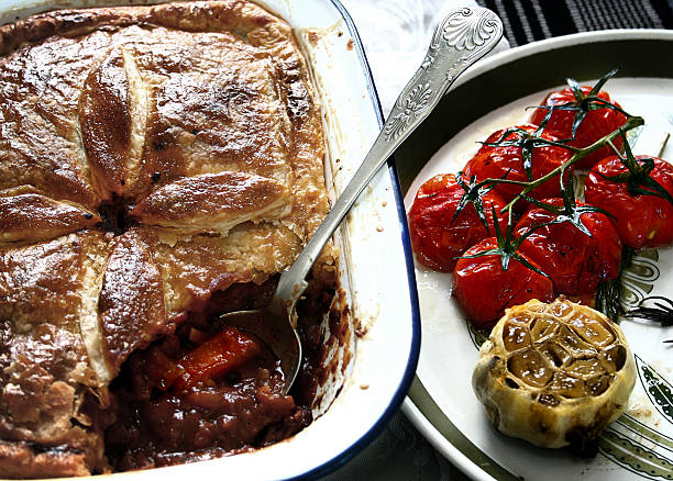 herzhaftes fleisch-torte mit geröstetem knoblauch & kirschtomaten - beef pie stock-fotos und bilder