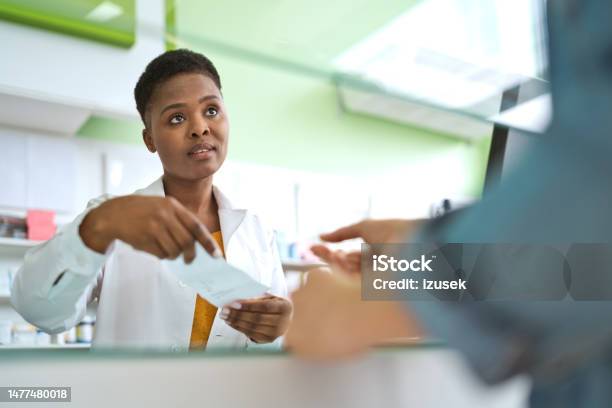 Female Pharmacist Talking With Customer Stock Photo - Download Image Now - Pharmacist, UK, Pharmacy