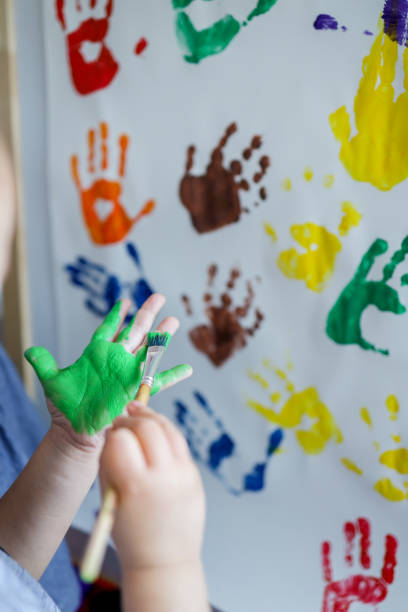 istock Children's master class in drawing, the child makes a handprint with paint. 1477480021