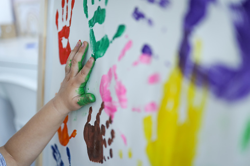 Children's master class in drawing, the child makes a handprint with paint.