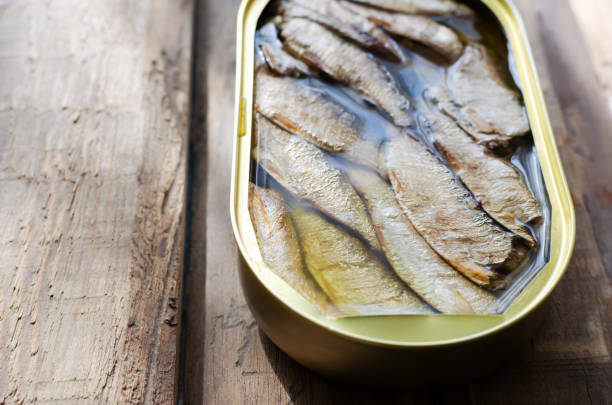 istock Canned fish on a wooden table. Tinned fish concept. Rustic style. Horizontal orientation. Copy space. 1477480740