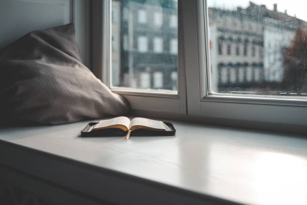 istock Open bible on windowsill, city view, morning prayer 1477482220