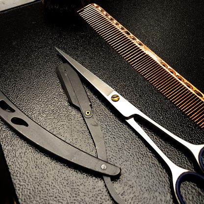 Scissors, comb and razor on barber's work table