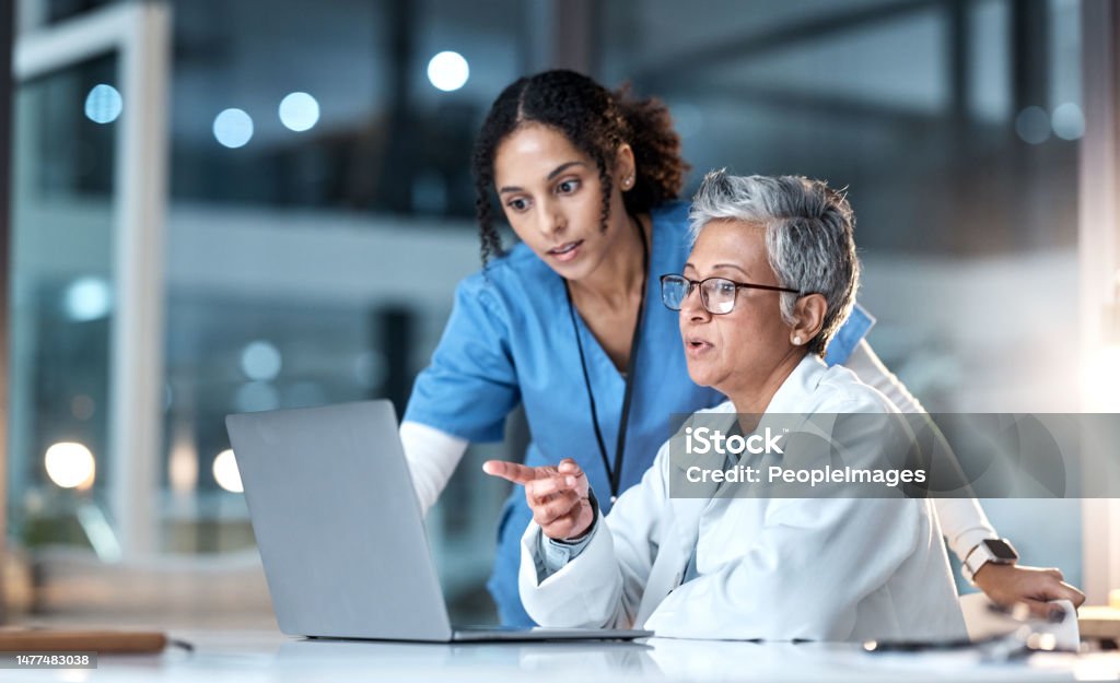 Doctors, nurse or laptop in night healthcare, planning research or surgery teamwork in wellness hospital. Talking, thinking or medical women on technology for collaboration help or life insurance app Doctor Stock Photo