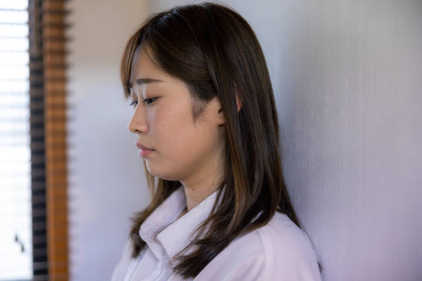 壁にもたれかかる女性患者 - うつ病 女性 日本人 ストックフォトと画像