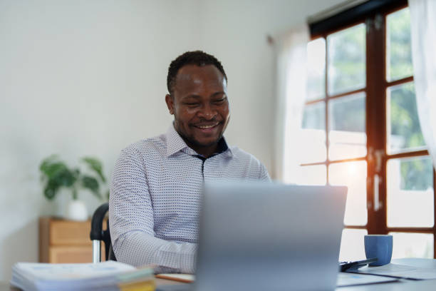 istock middle aged man American African using computer laptop with planning working on financial document, tax, exchange, accounting and Financial advisor 1477485528